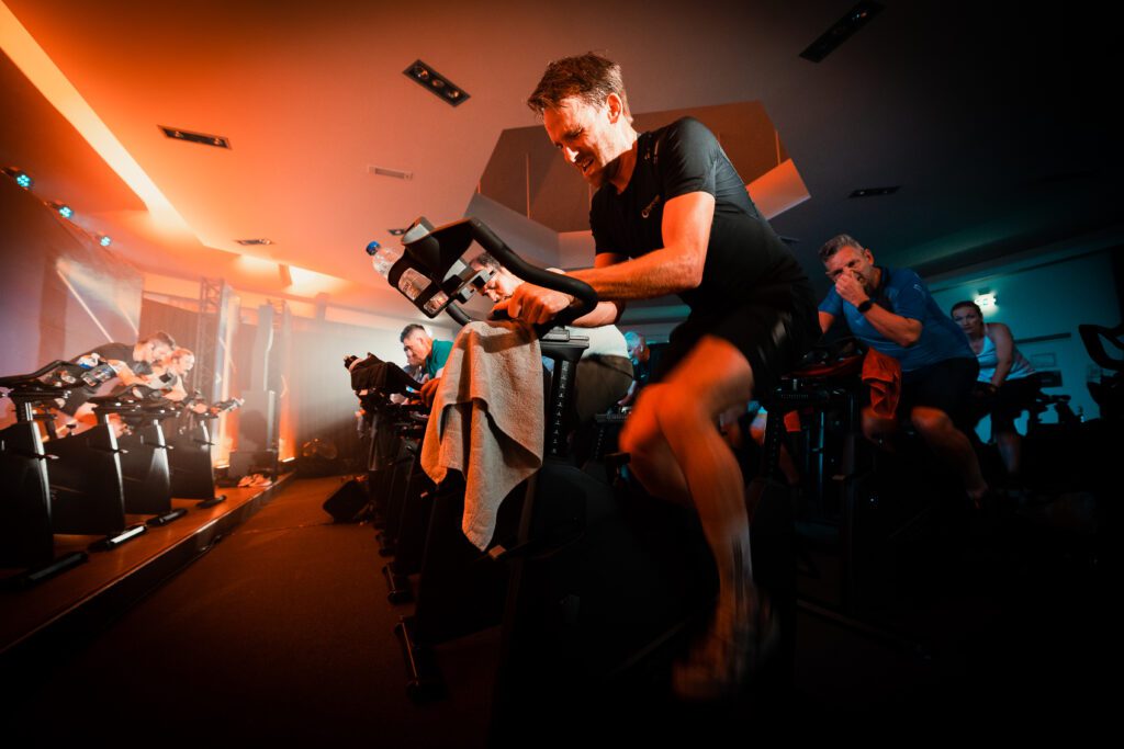 Man riding a body bike in a group fitness class